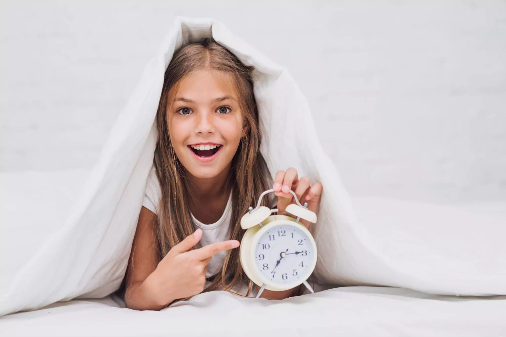 An image of a girl playing with the clock and developing time management skills.
