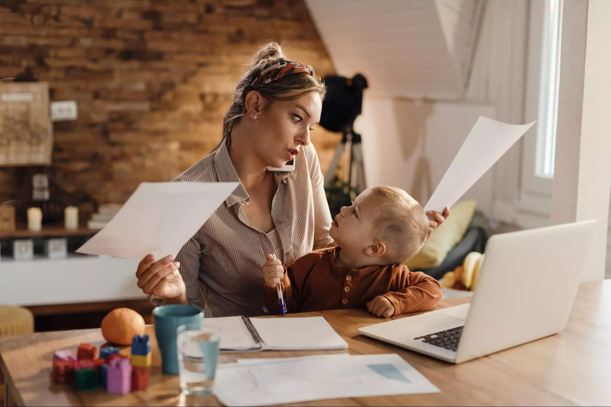An entrepreneur spending time with her child while managing business tasks.